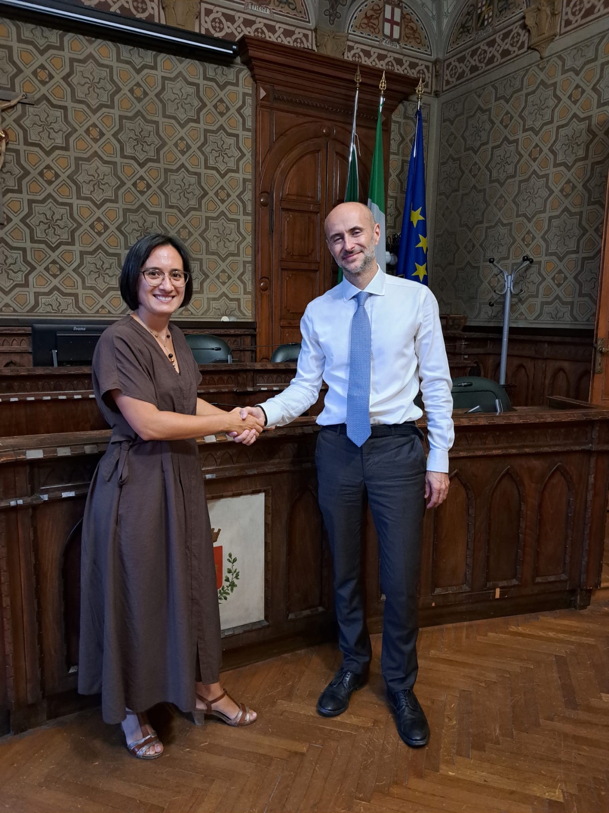 Councillor Valentina Giro and David Falconi shaking hands in the Rho town hall